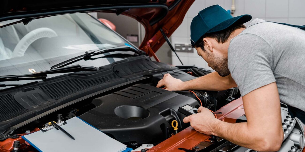 auto mechanic with multimeter voltmeter checking c 7MTRPJF